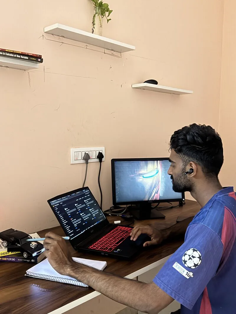 An engineer working at a desk with a laptop and a second screen